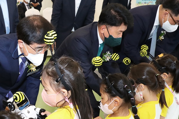 함영주 하나금융그룹 회장(사진 가운데)과 강순희 근로복지공단 이사장(사진 왼쪽)이 행사에 참석한 관계자들과 함께 원아들에게 인공지능 코딩 강아지 로봇을 선물하고 있다. [사진=하나금융그룹]