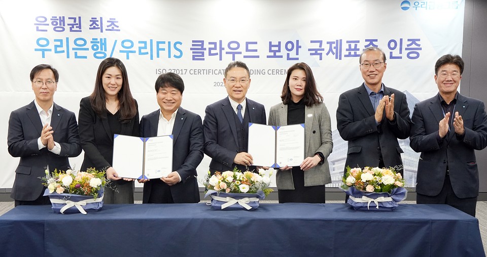 고정현 우리은행 IT그룹 부행장 겸 우리에프아이에스 대표(가운데), 김백수 우리은행 정보보호그룹 부행장(왼쪽 세번째), 이소영 DNV BA 코리아 대표(왼쪽 두번째)가 관계자들과 기념촬영을 하고 있다. [사진=우리금융그룹]