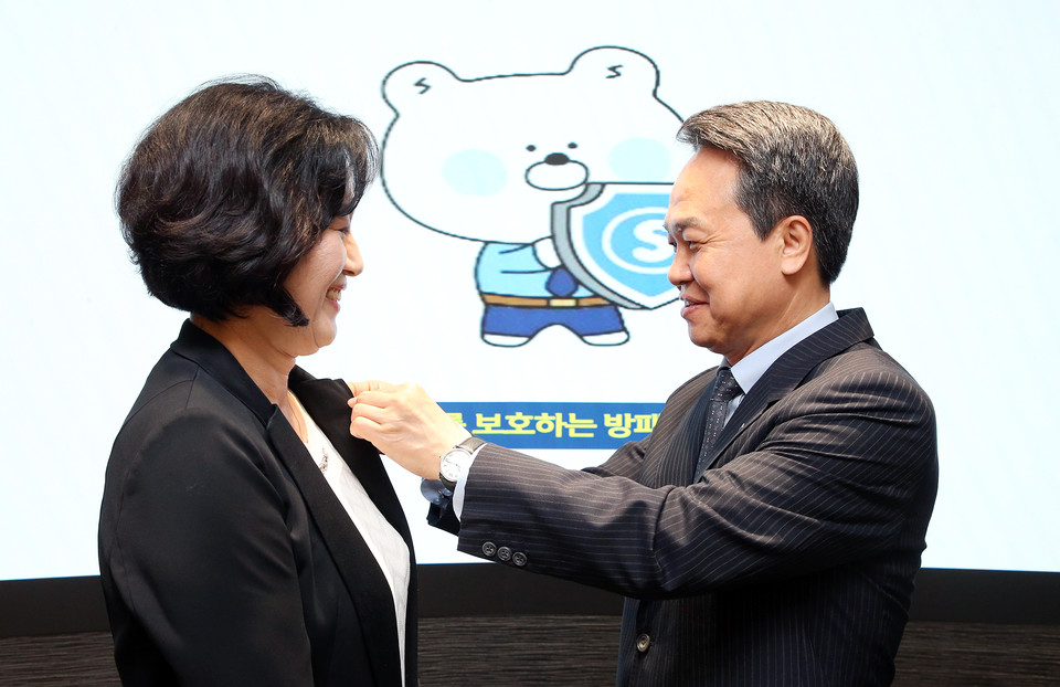 진옥동 신한금융그룹 회장(오른쪽)이 박현주 신한금융지주 부사장에게 소비자보호 뱃지를 달아주고 있다. [사진=신한금융]