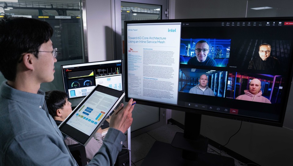 SK텔레콤과 인텔 연구원들이 공동 기술을 검증한 백서에 대해 논의하는 모습 [사진=SK텔레콤]