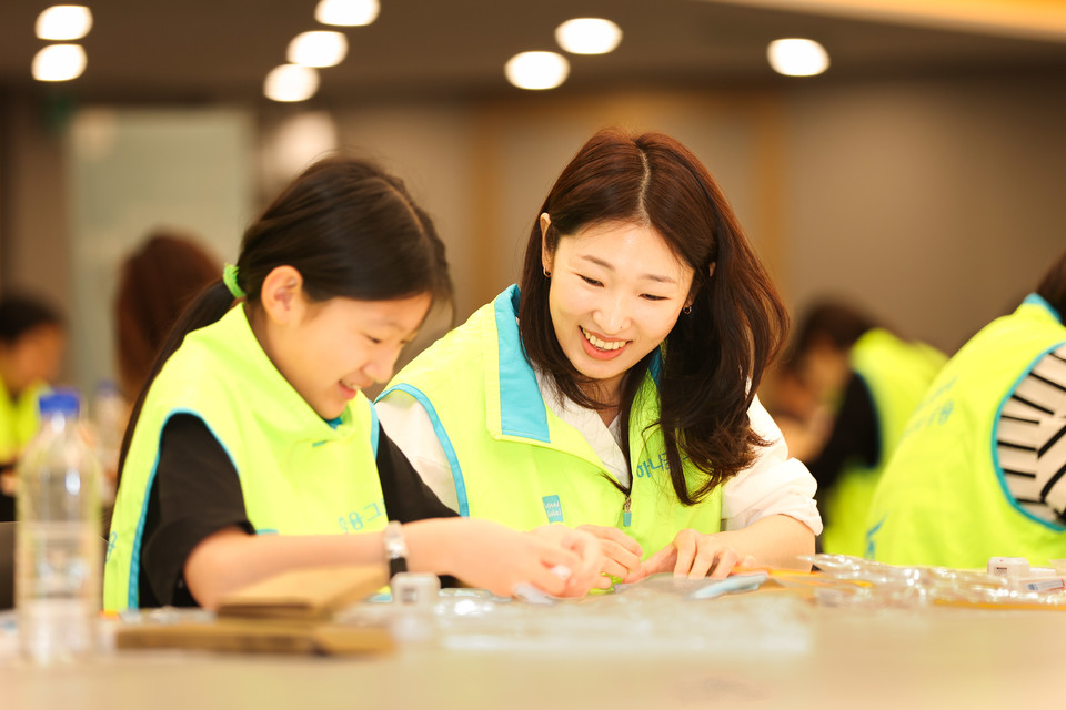 봉사활동에 참여한 하나금융그룹 직원과 가족이 시각장애인용 점자 교구를 제작하고 있다. [사진=하나금융]