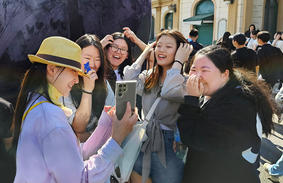 AI 전문 사진작가가 1020세대 방문객들에게 갤럭시S24로 사진 촬영 후 생성형 편집 기능으로 완성한 작품을 공유하고 있다. [사진=삼성전자]