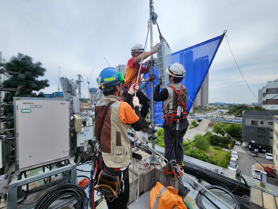 SK텔레콤 시설관리 관련 직원들이 건물 옥탑 기지국의 안전시설물을 확인하고 작업하는 모습 [사진=SK텔레콤]