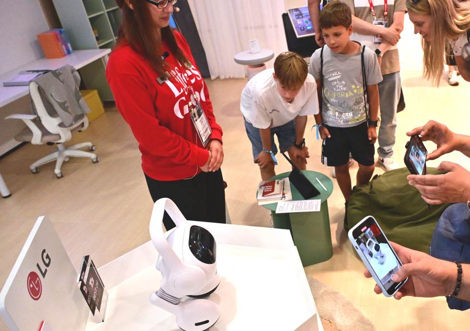 LG전자 전시관을 찾은 관람객이 '이동형 AI홈 허브(코드명: Q9)'를 살펴보고 있는 모습 [사진=LG전자]