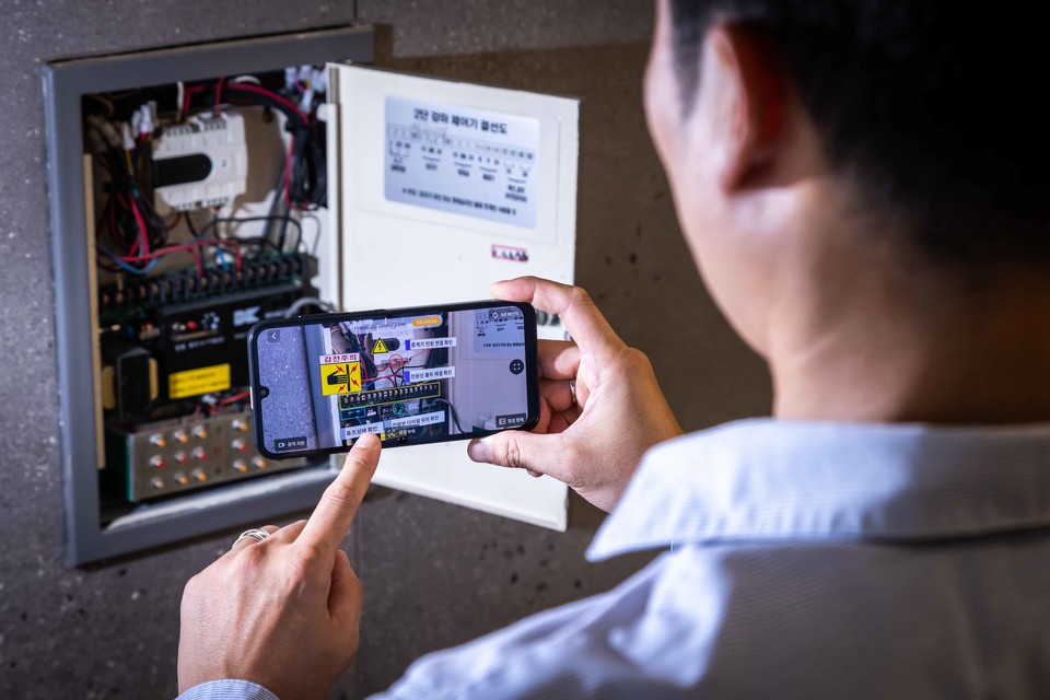 SK텔레콤 엔지니어가 스마트폰 AR 화면을 통해 솔루션을 테스트하고 있다. [사진=SK텔레콤]