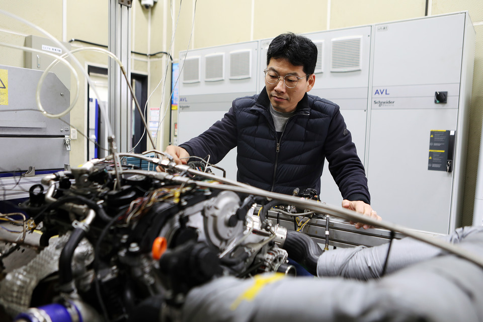 기계연 박철웅 책임연구원이 이번에 개발한 암모니아 엔진을 살펴보고 있다. [사진=기계연]
