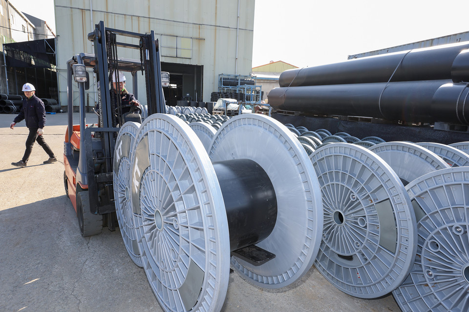 KT 직원이 경기도 김포시 소재 아시아플라텍 공장에서 제조된 친환경 보빈을 점검하고 있다. [사진=KT]