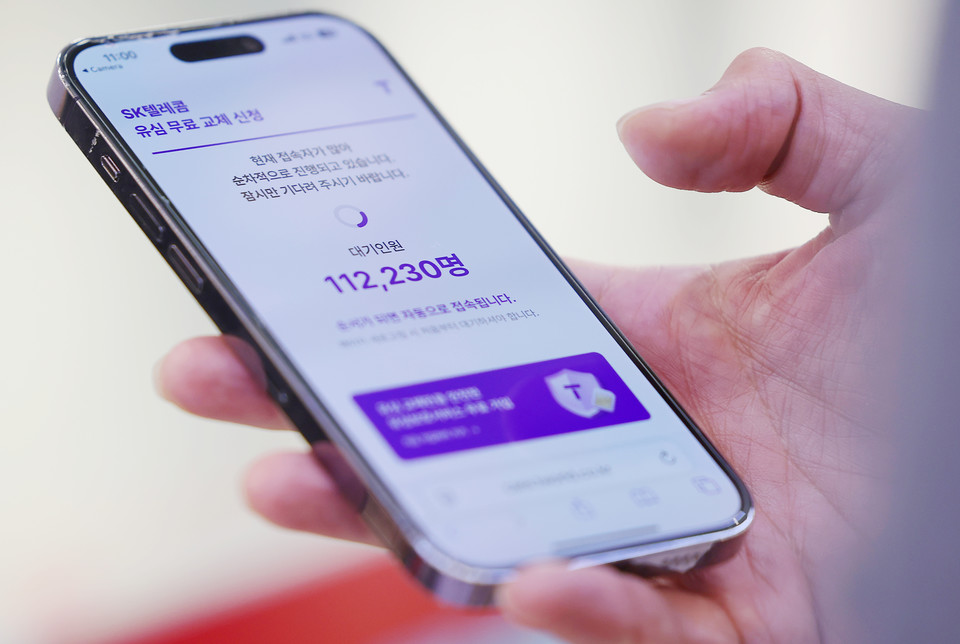 SK텔레콤이 유심 고객정보 해킹 사고로 관련 유심 무료 교체 서비스에 나선 지난 28일 오전 11시 경 서울 시내 한 SK텔레콤 대리점에서 한 고객이 유심 교체 신청 QR코드를 찍자 접속 대기인원이 11만명 이상을 표시하고 있다. [사진=연합뉴스]