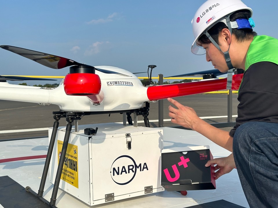 LG유플러스 엔지니어가 제주도에 구축된 드론배송 거점에서 드론에 스마트폰을 싣고 있다. [자료사진=LG유플러스]