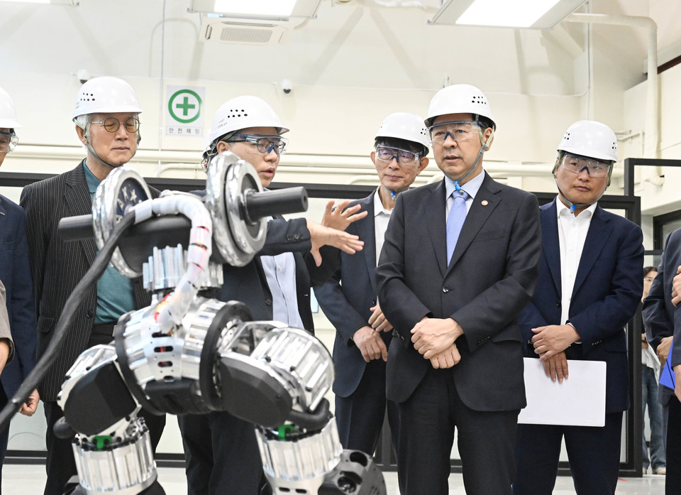 구윤철 부총리 겸 기획재정부 장관이 19일 'AI 대전환 릴레이 현장 간담회'로 AI 팩토리 분야 추진계획 등을 논의하고자 대전시 유성구 카이스트 AI 팩토리 랩을 방문해 간담회 시작에 앞서 박사과정 대학원생들과 휴머노이드 로봇 대화를 나누고 있다. [사진=기획재정부]