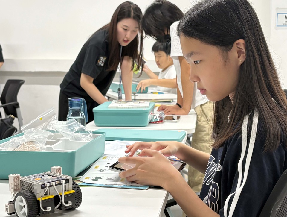 참가학생이 네오씽카 교구를 활용해 제작한 자동차를 바탕으로 블록코딩 실습을 하고있다. [사진=CJ올리브네트웍스]